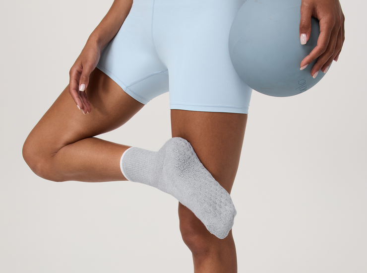 Vuori model wearing a matching black set and gray and white socks from Vuori