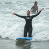 woman surfing on her knees at boarding for breast cancer event