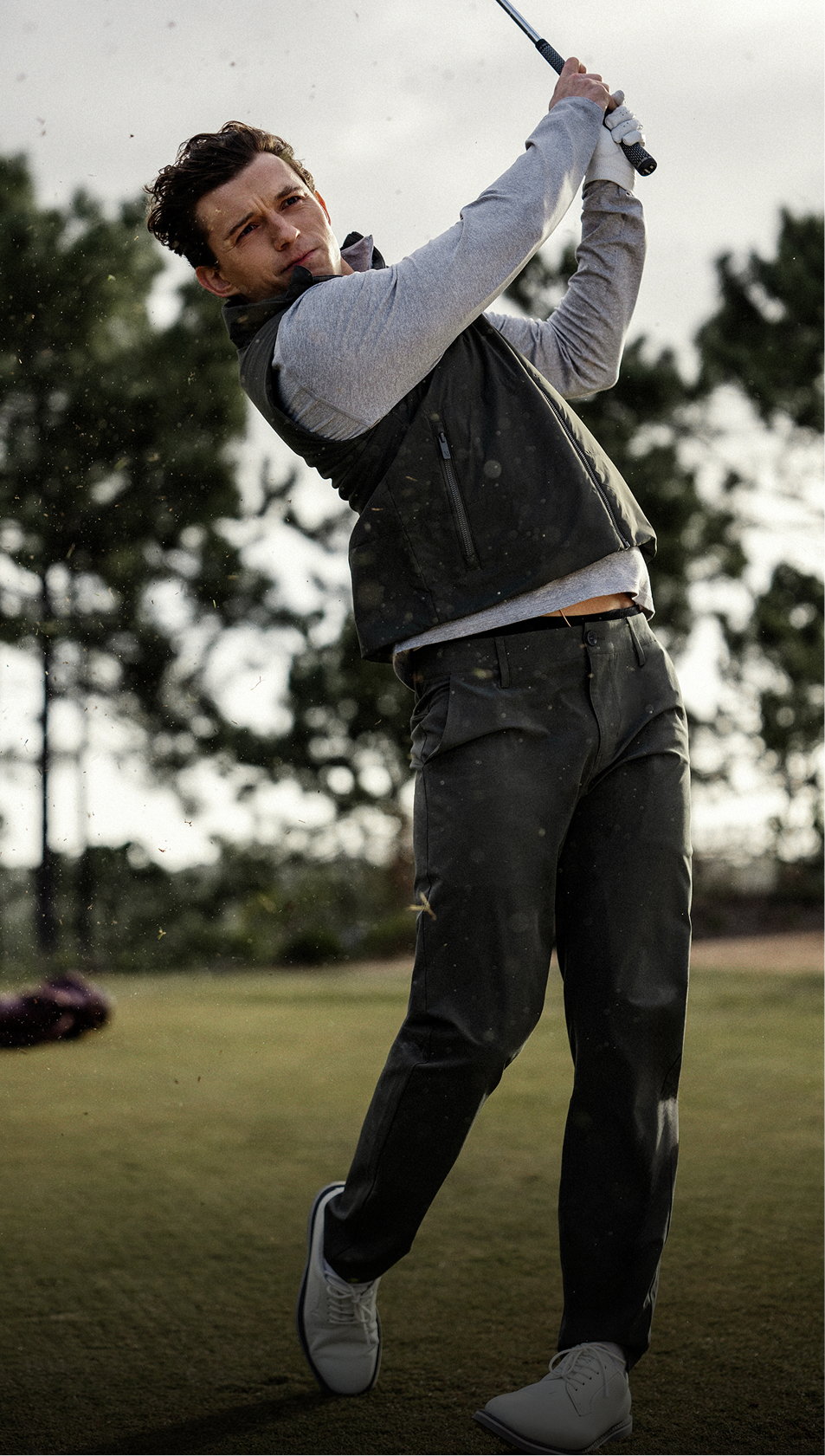 Tom Holland teeing off in the Vuori Aim Pant