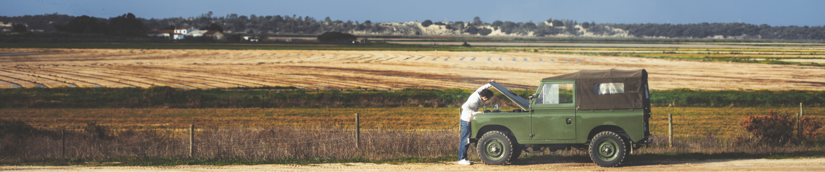 tom holland next to car in front of field