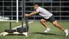 man training pushing a weighted sled on turf