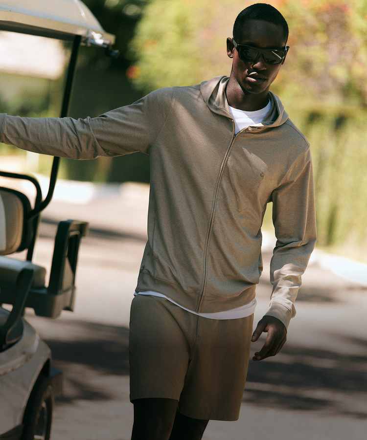 man and woman wearing vuori clothing on golf cart