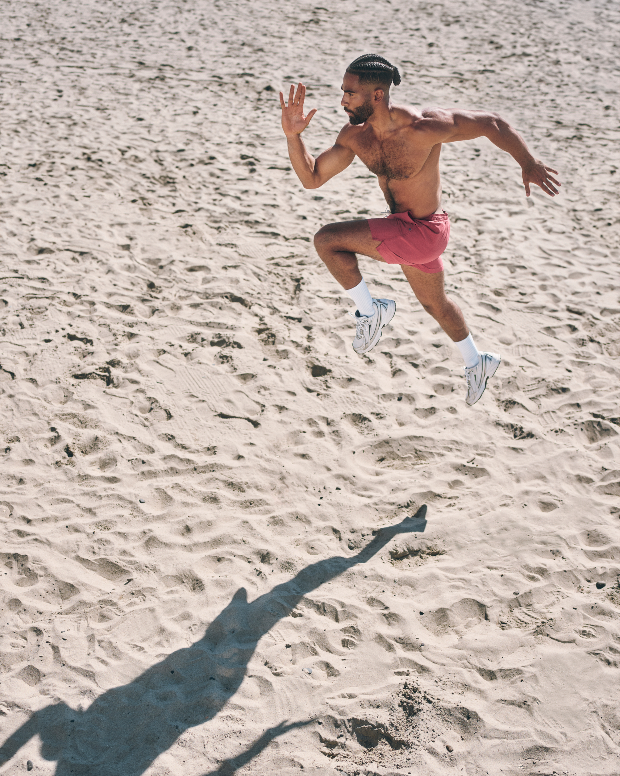 man working out on beach wearing vuori