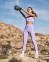 woman wearing vuori swinging a kettlebell in the desert