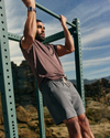 man wearing vuori doing pull ups in the desert