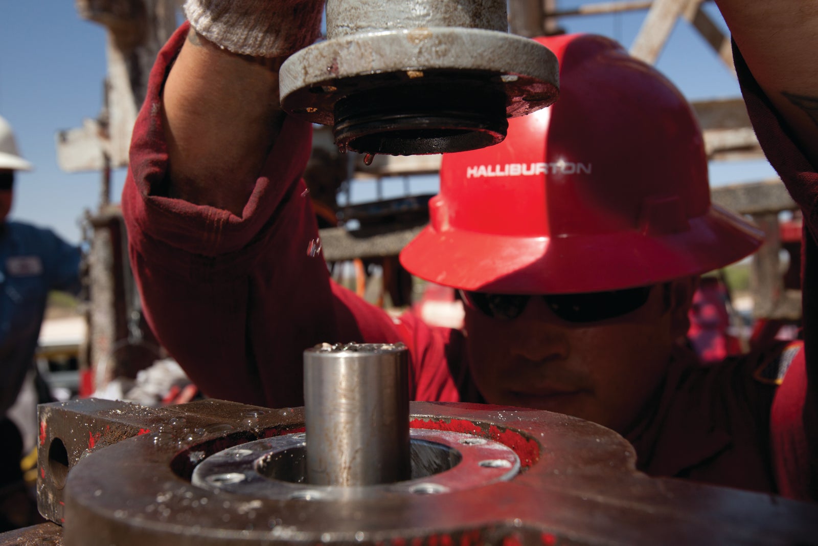 Two Halliburton employees collaborating at a well site