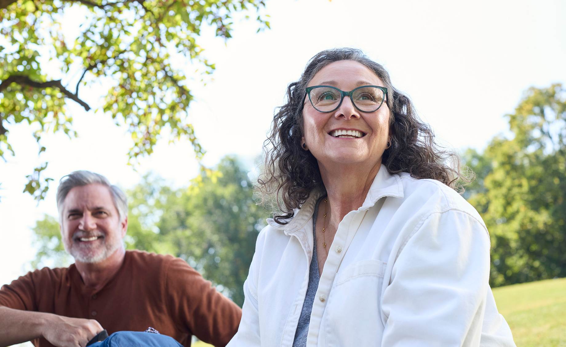 Smiling adult woman outdoors with a confident expression, representing comfort and confidence related to denture care.