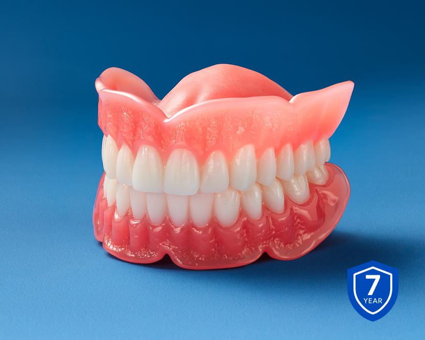 Full upper and lower denture model with pink gum base displayed on a blue background, highlighting a 7-year warranty.