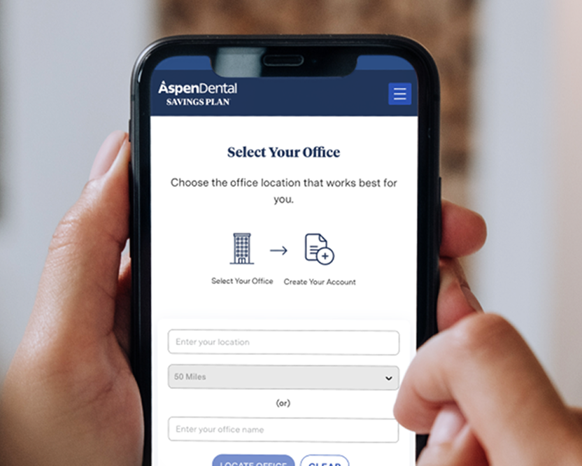 Alt text:
Person holding a smartphone displaying the Aspen Dental Savings Plan office selection page.