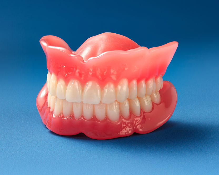 A full set of artificial upper and lower signature dentures used to restore missing teeth.