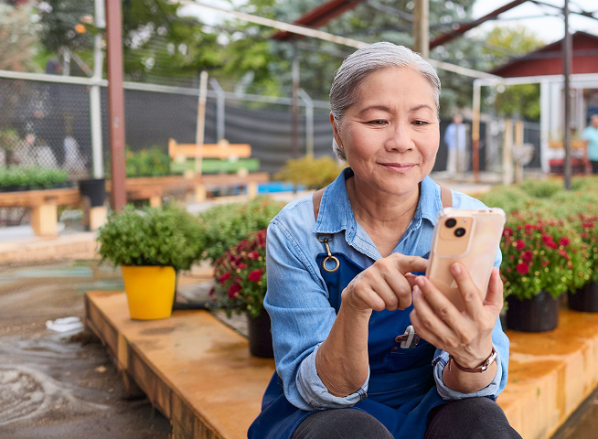 Woman using a smartphone in a garden nursery