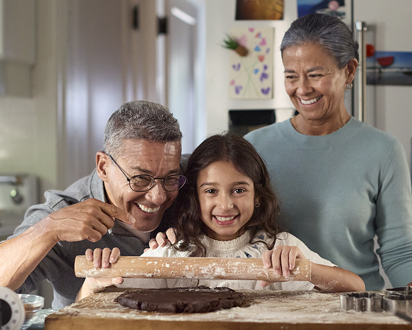 Grandparents and granddaughter joyfully baking together
