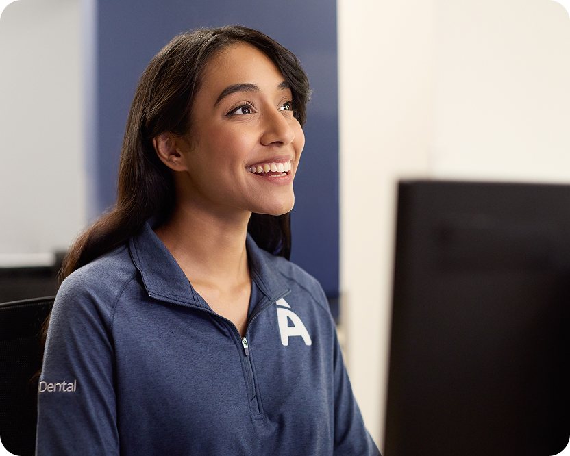Alt text:
Aspen Dental team member smiling while assisting a patient.