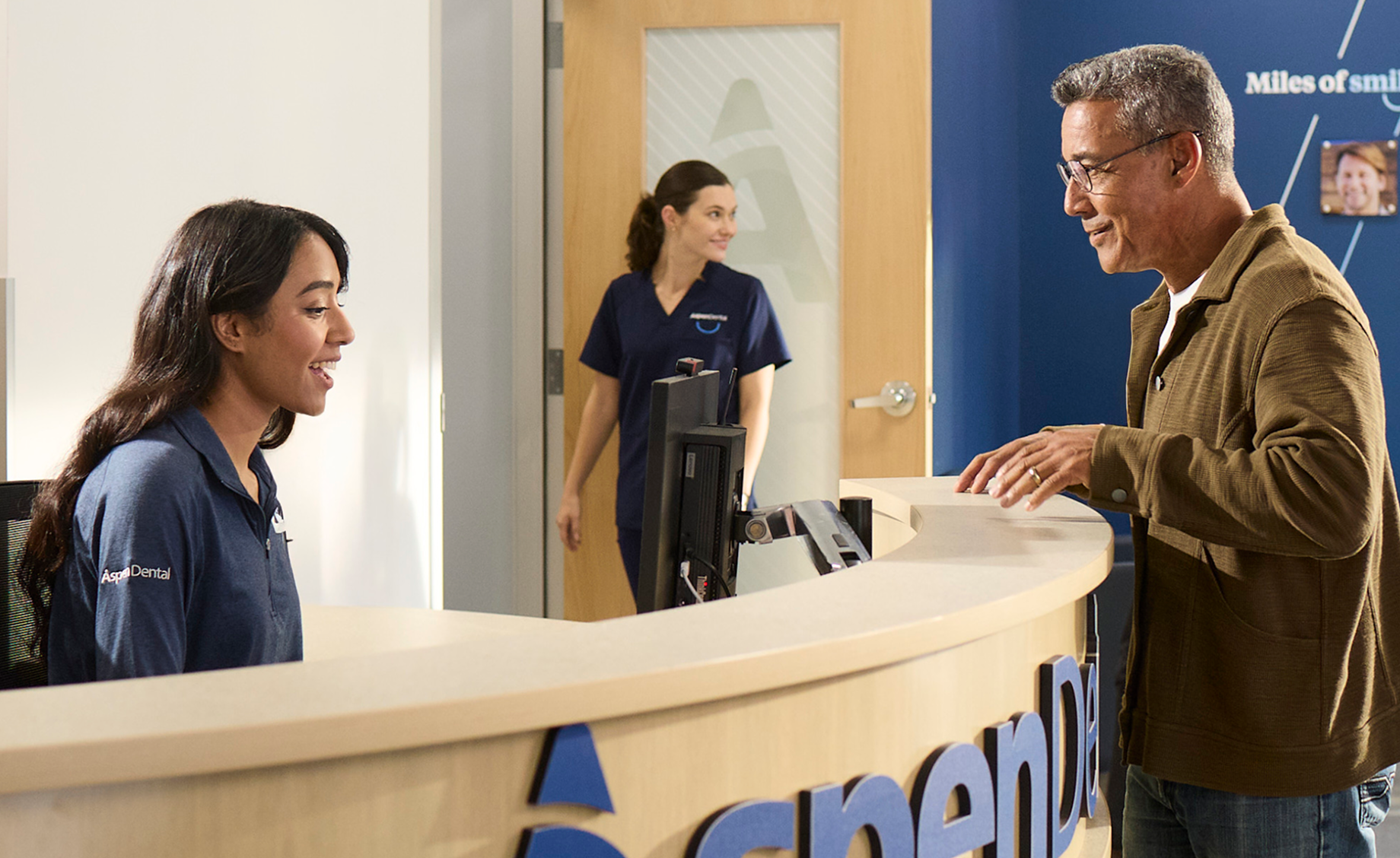 Patient checking in at Aspen Dental office for a cosmetic dentistry consultation to review treatment options and costs.