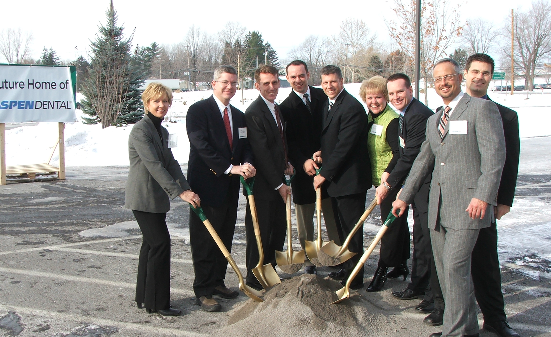 Alt text: Aspen Dental team members participating in a groundbreaking ceremony with ceremonial shovels.