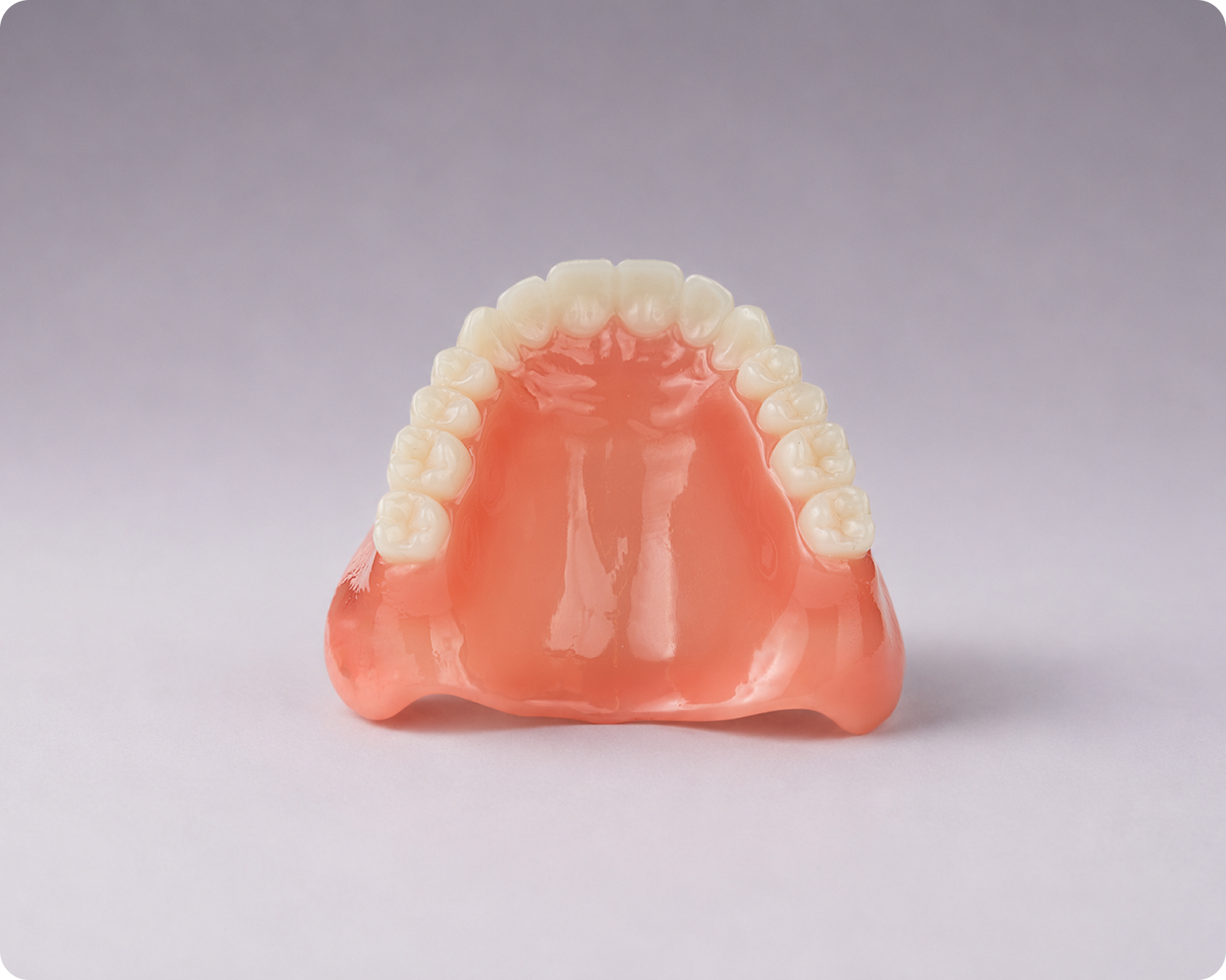 A full upper Signature Elite denture highlighting the roof of the mouth view against a gray background