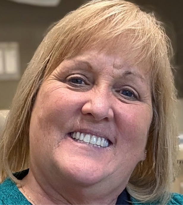 A woman smiles after receiving dental implants