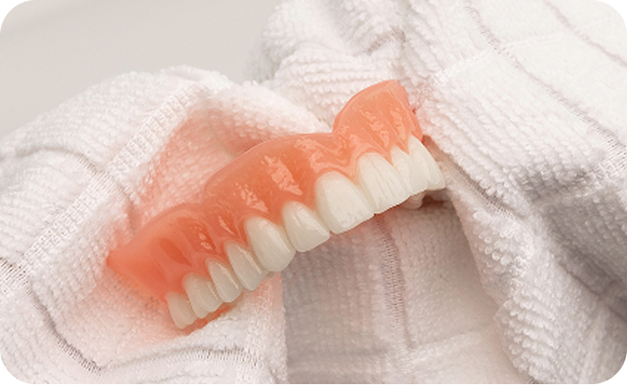 Denture resting on a towel after cleaning.