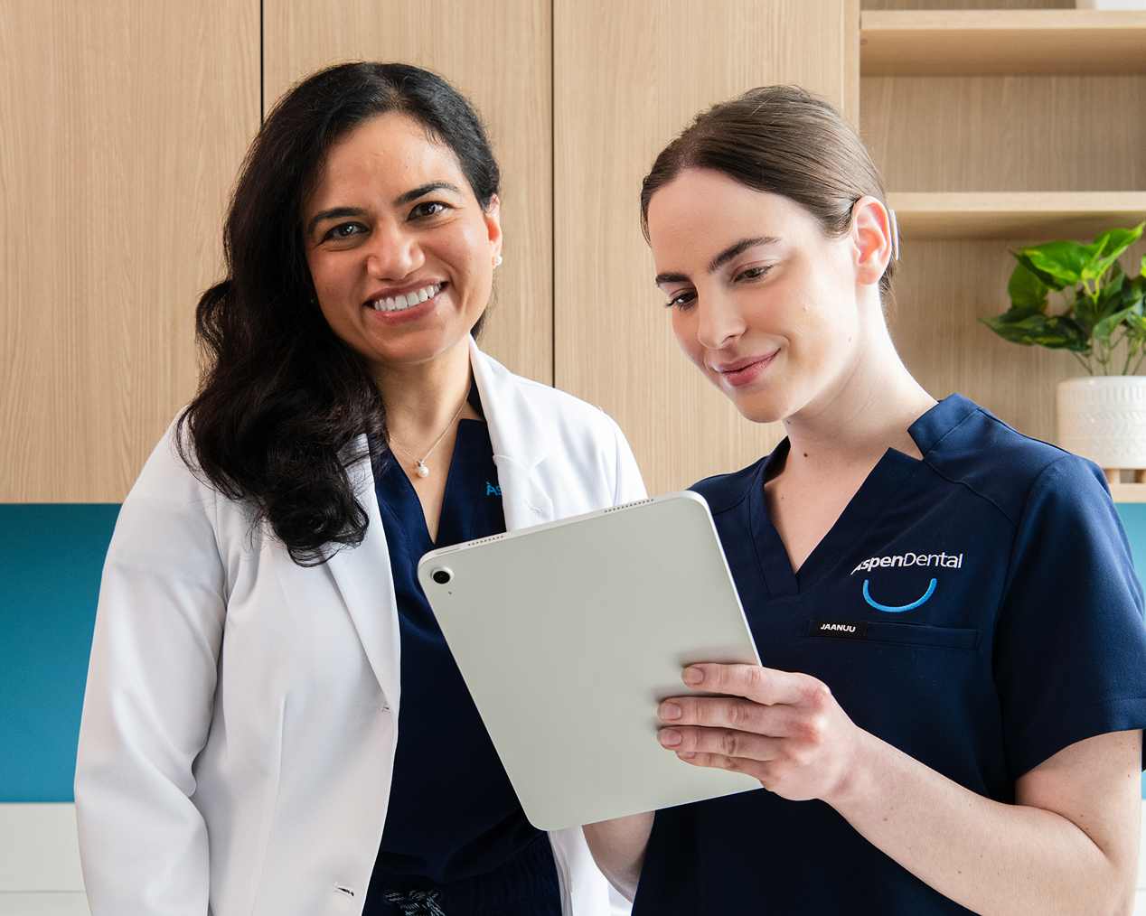 Alt text:
Aspen Dental professionals reviewing information on a tablet together in a dental office.