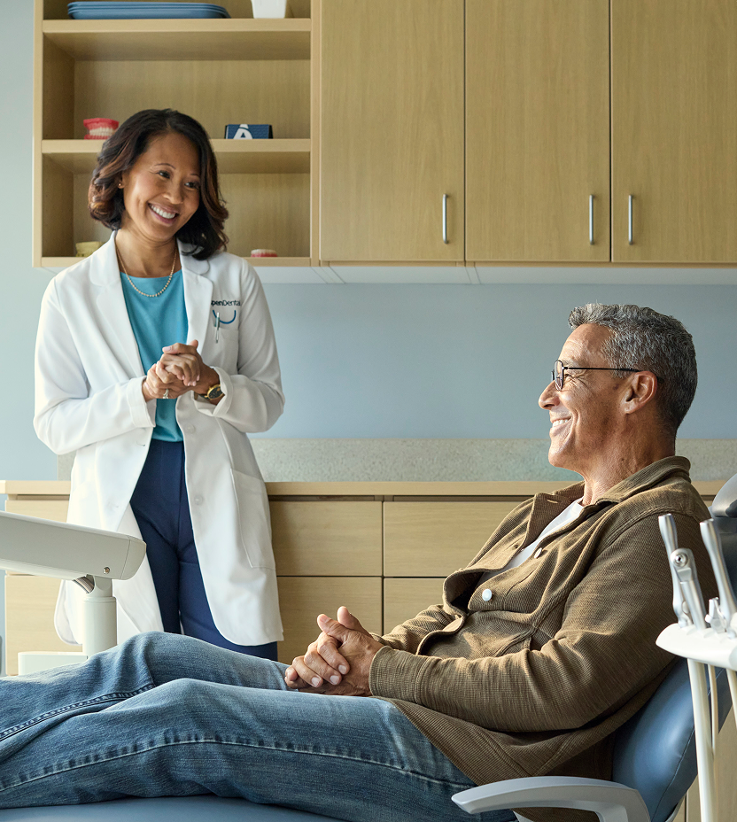Female dentist speaking with a patient during a consultation in an exam room.