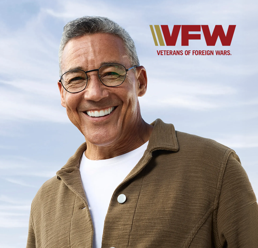 Smiling older adult man outdoors with the VFW (Veterans of Foreign Wars) logo displayed.