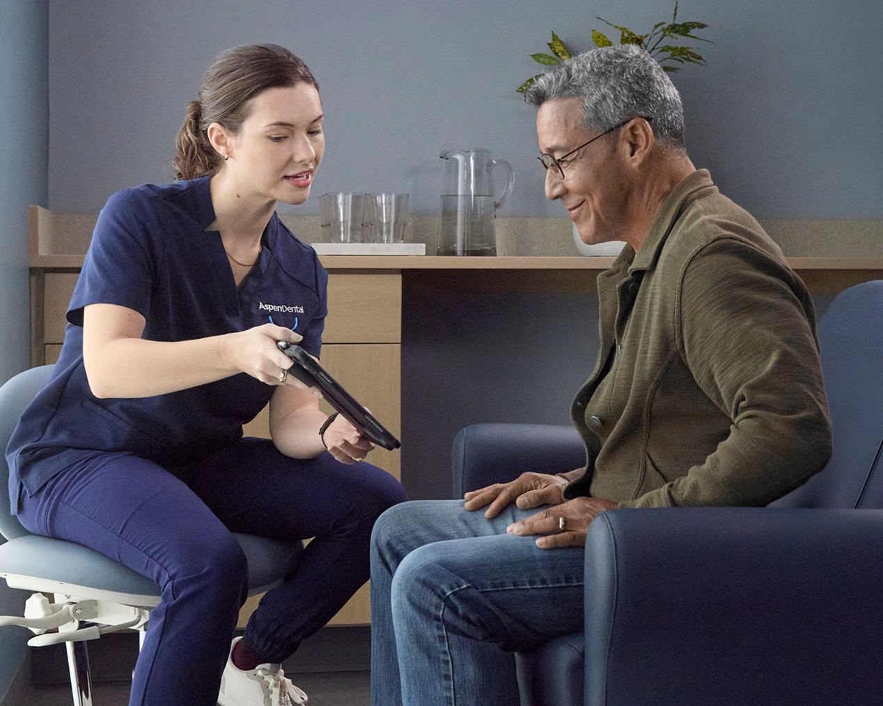 Aspen Dental team member reviewing information on a tablet with a patient.