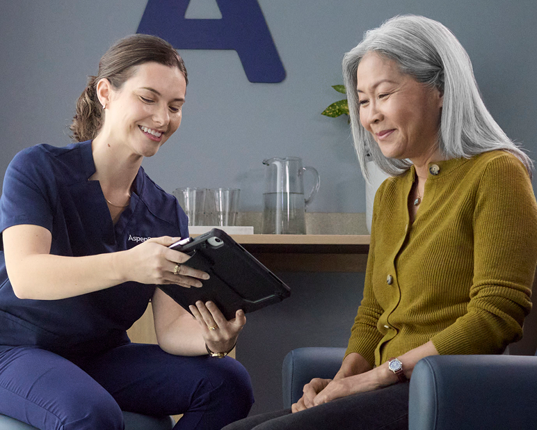 Aspen Dental team member reviewing information on a tablet with a patient during a visit.