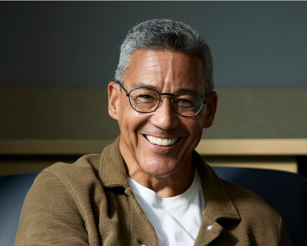 Alt text:
Smiling older adult man wearing glasses with a confident expression.