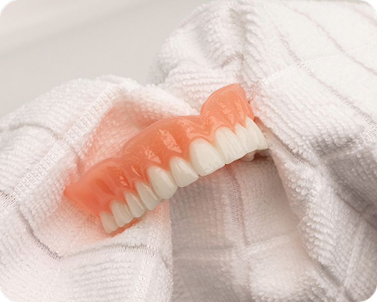 Denture resting on a towel after cleaning.