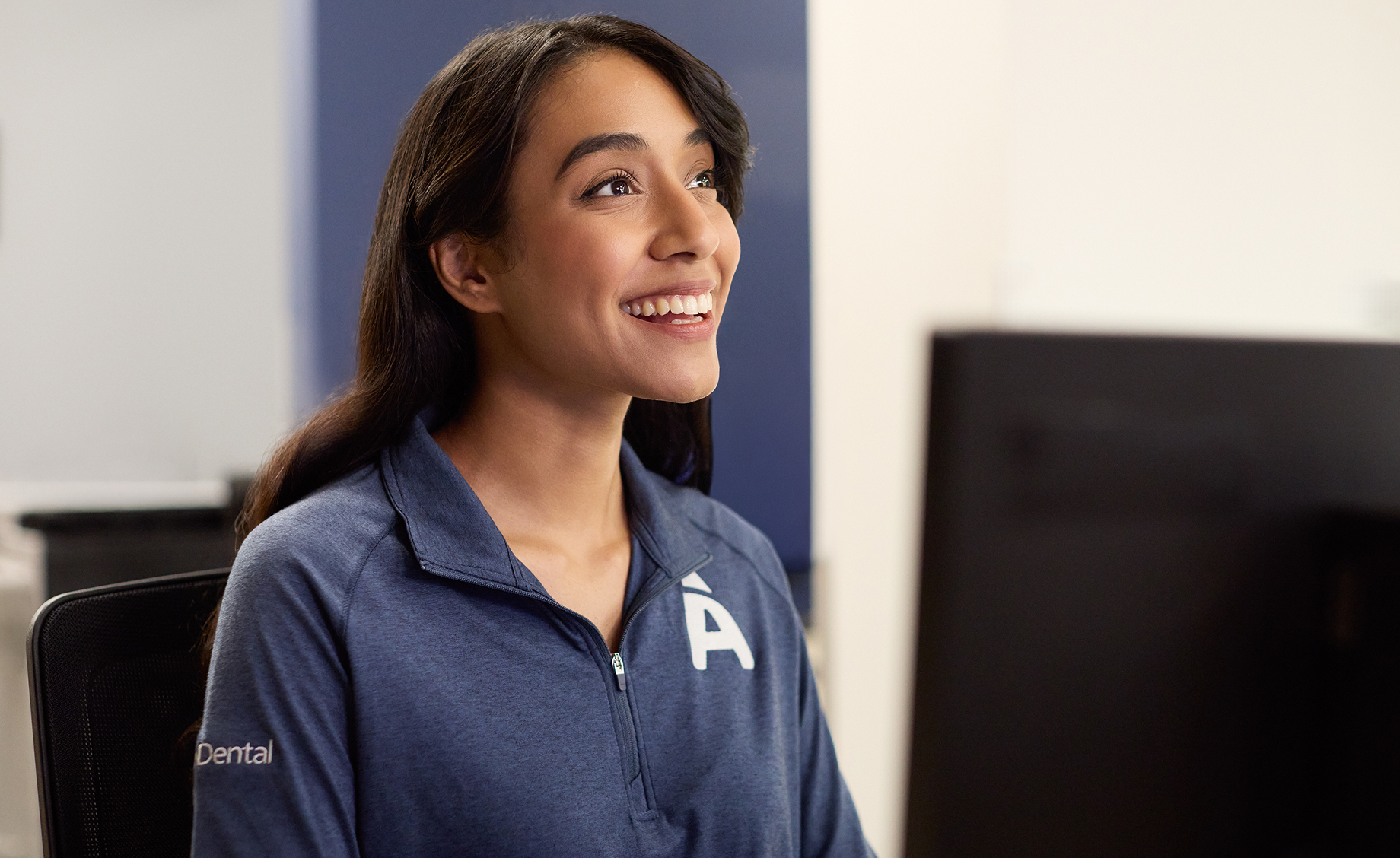 Aspen Dental team member smiling while assisting a patient.