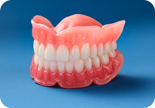Full set of dentures with pink gums and white teeth displayed on a blue background.