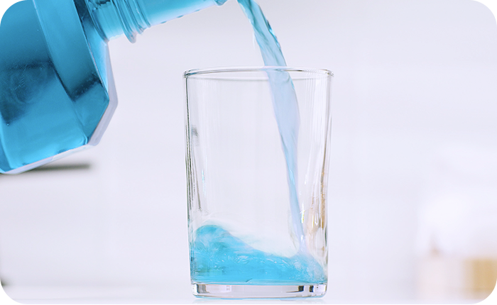 Alt text:
Blue mouthwash being poured into a glass.