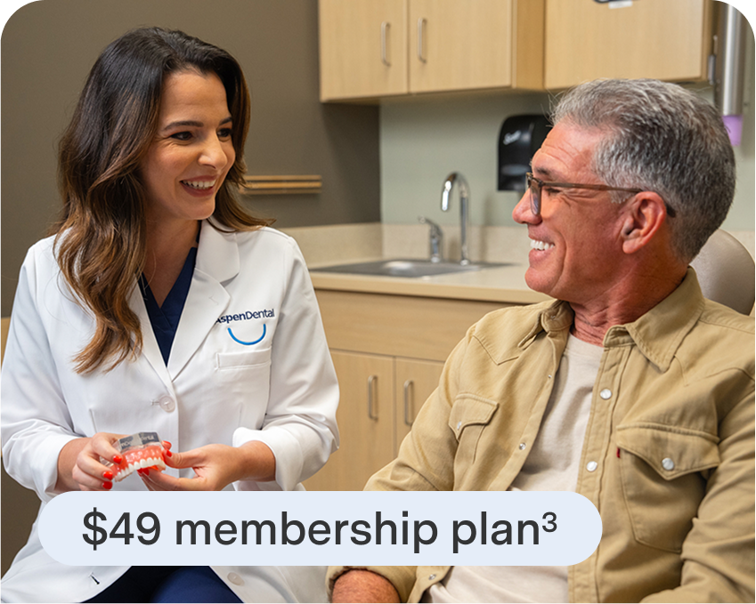Aspen Dental team member smiles confidently in office with a caption noting 99% of patients approved for financing.