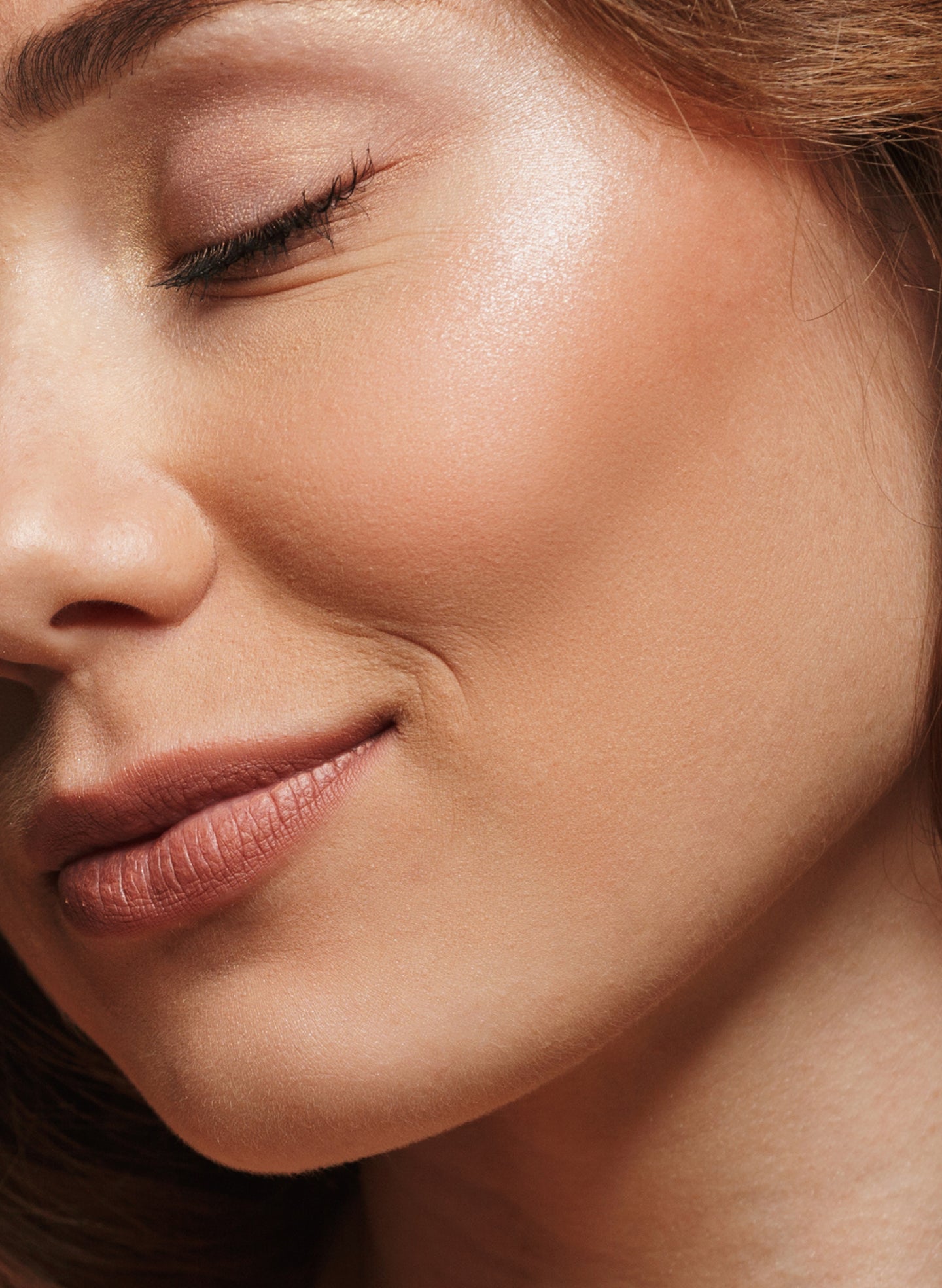 A close-up view of a woman’s smooth, glowing skin showing soft texture and natural radiance after a facial treatment at an aesthetics studio. The image highlights healthy complexion and subtle contouring.