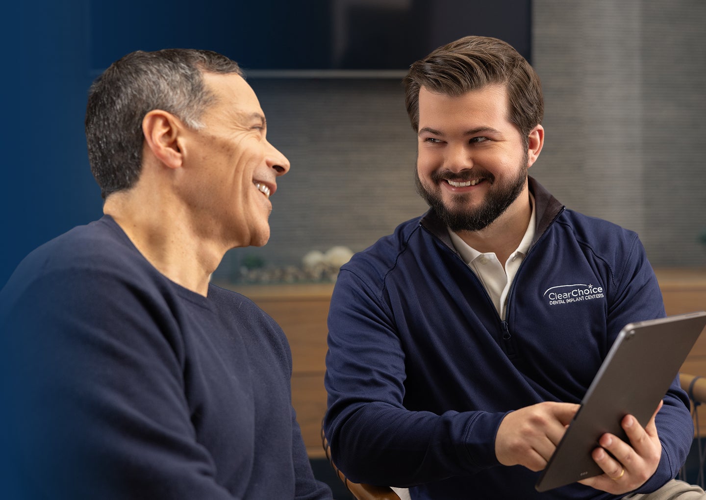 A ClearChoice professional reviews insurance coverage with a patient and explains billing and financing options in a consultation room.