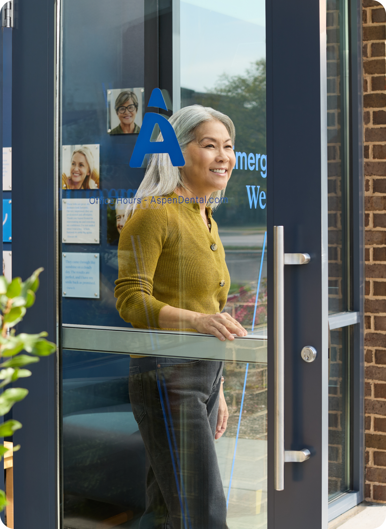 A smiling woman leaving an Aspen Dental office