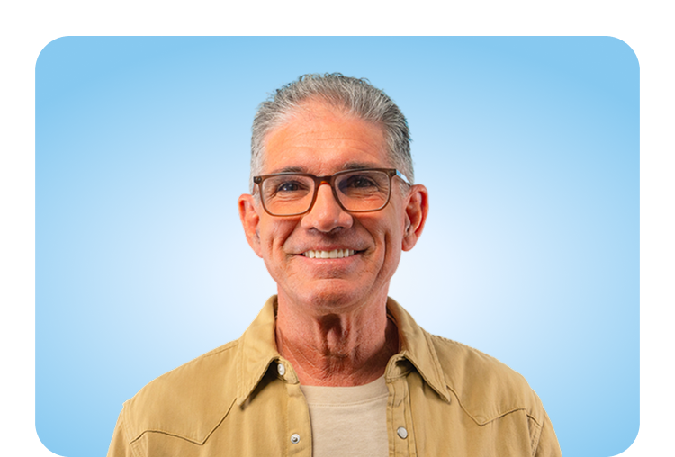 Smiling older man after receiving dental implants at Aspen Dental, showing restored confidence and natural-looking tooth replacement.