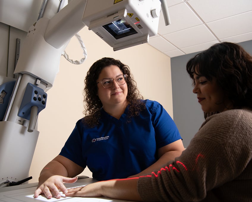 A provider gives a patient a hand x-ray.