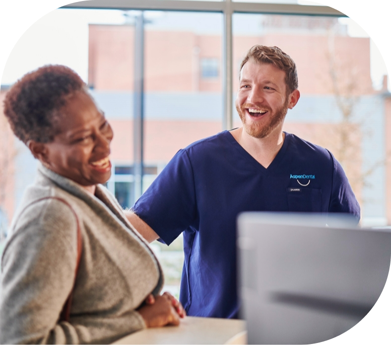 A man in a blue scrub is talking to a woman