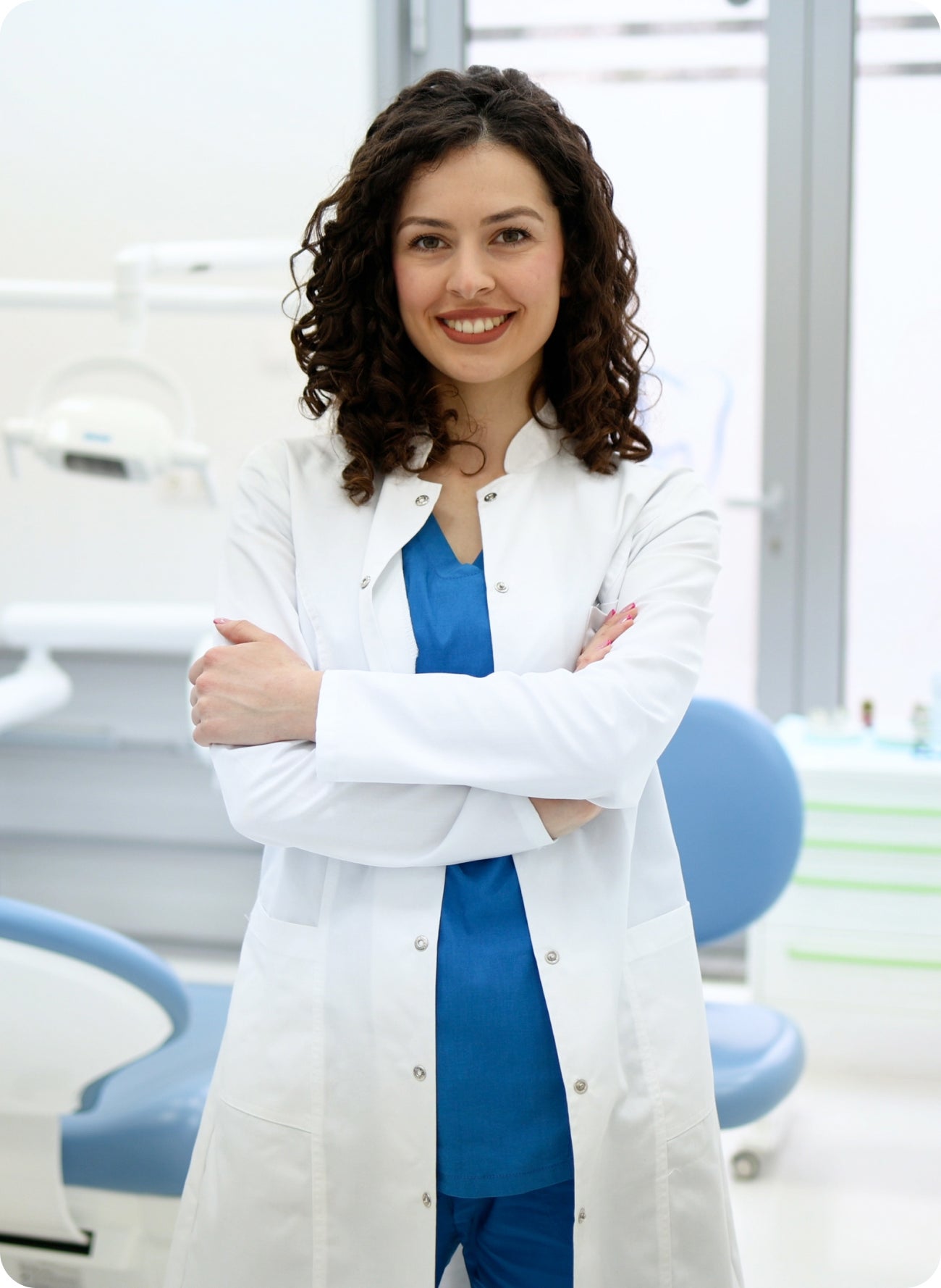 A smiling female dentist in a white coat