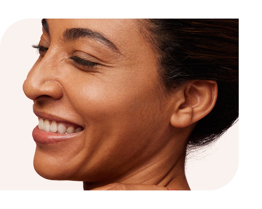 A side profile image of a woman smiling joyfully, eyes closed
