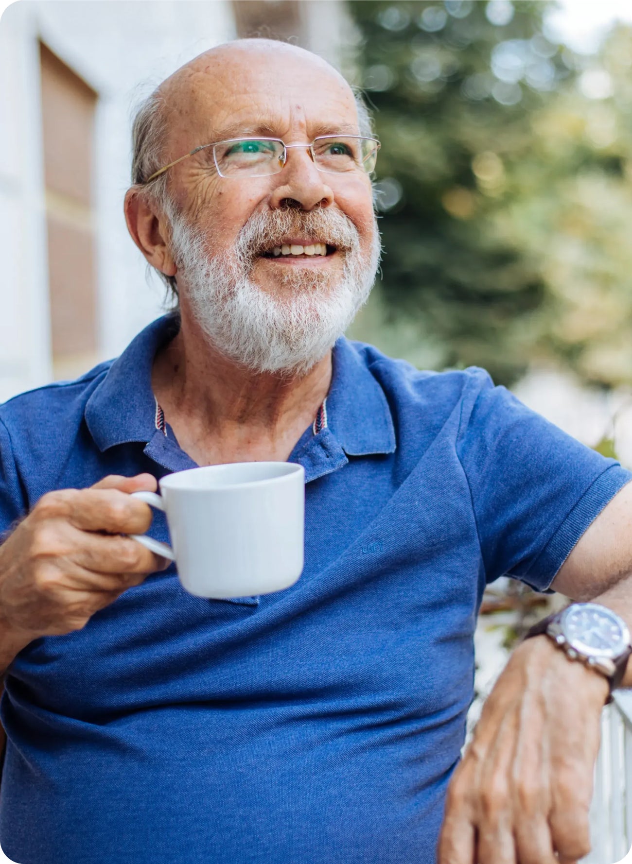 Older man holding a cup of coffee outdoors, suggesting tips for drinking coffee without staining teeth.