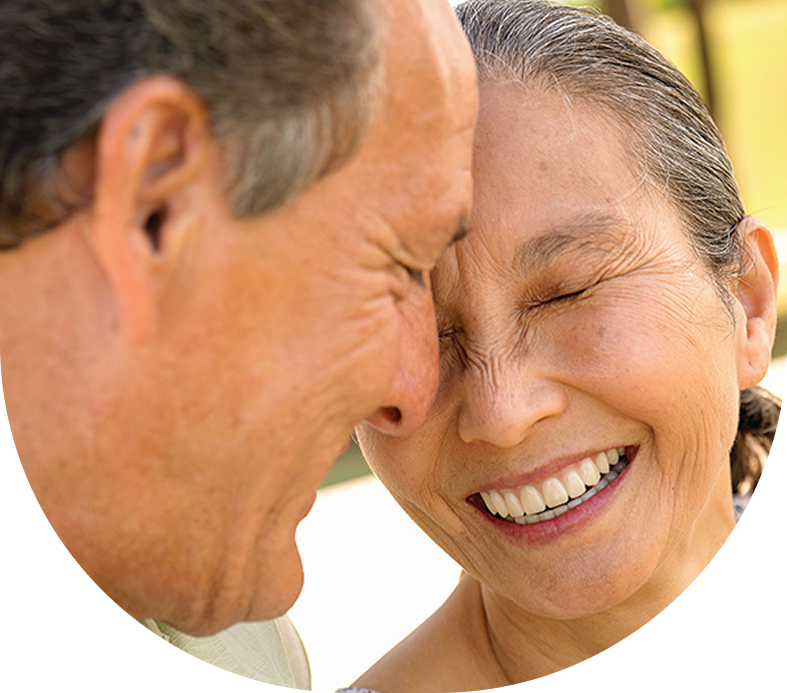 A man and woman are smiling with their eyes closed