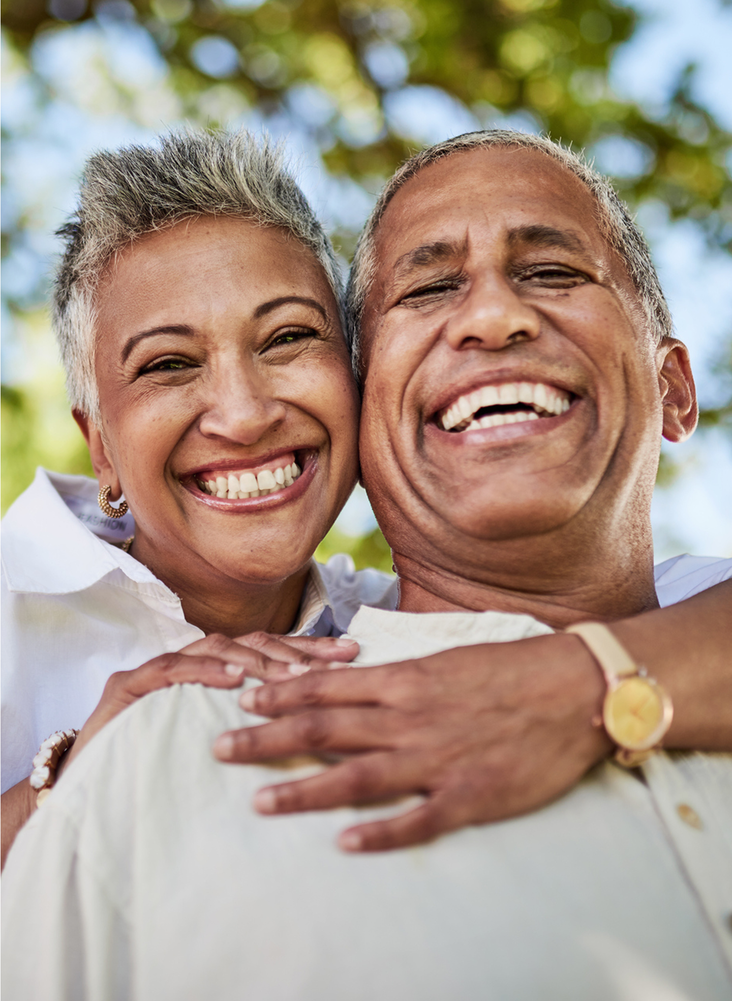 An older couple joyfully smiling and laughing, radiating happiness and warmth in their expressions.