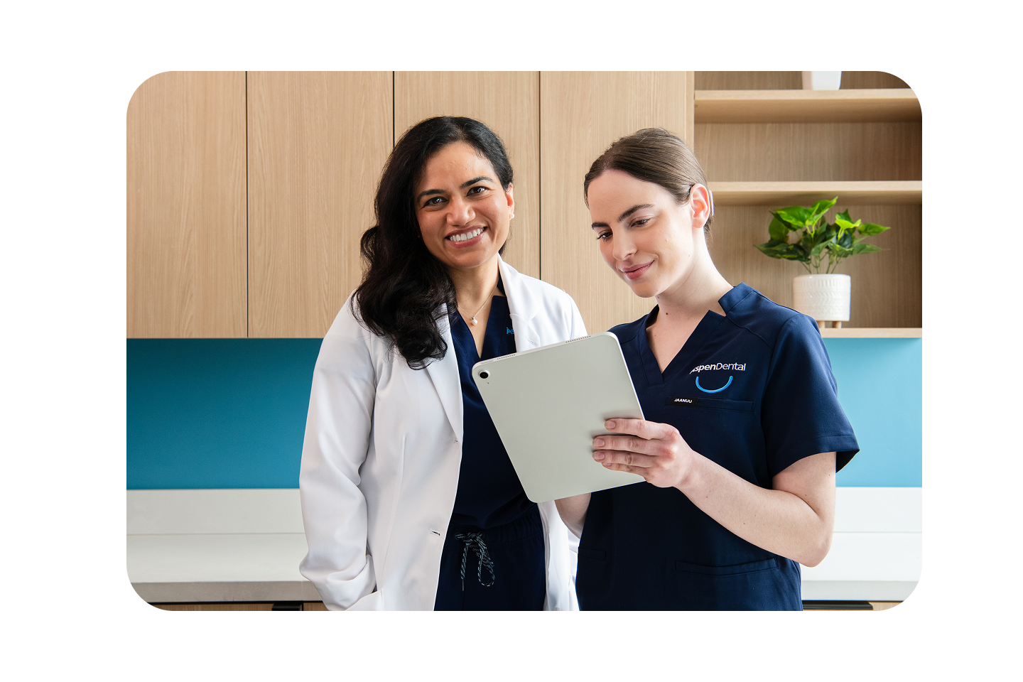 Two Aspen Dental team members reviewing a tablet.