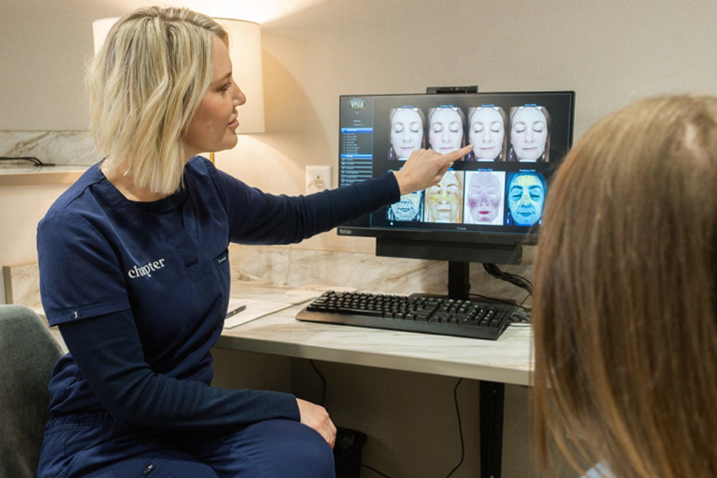 Professional discussing skin assessment results with a guest