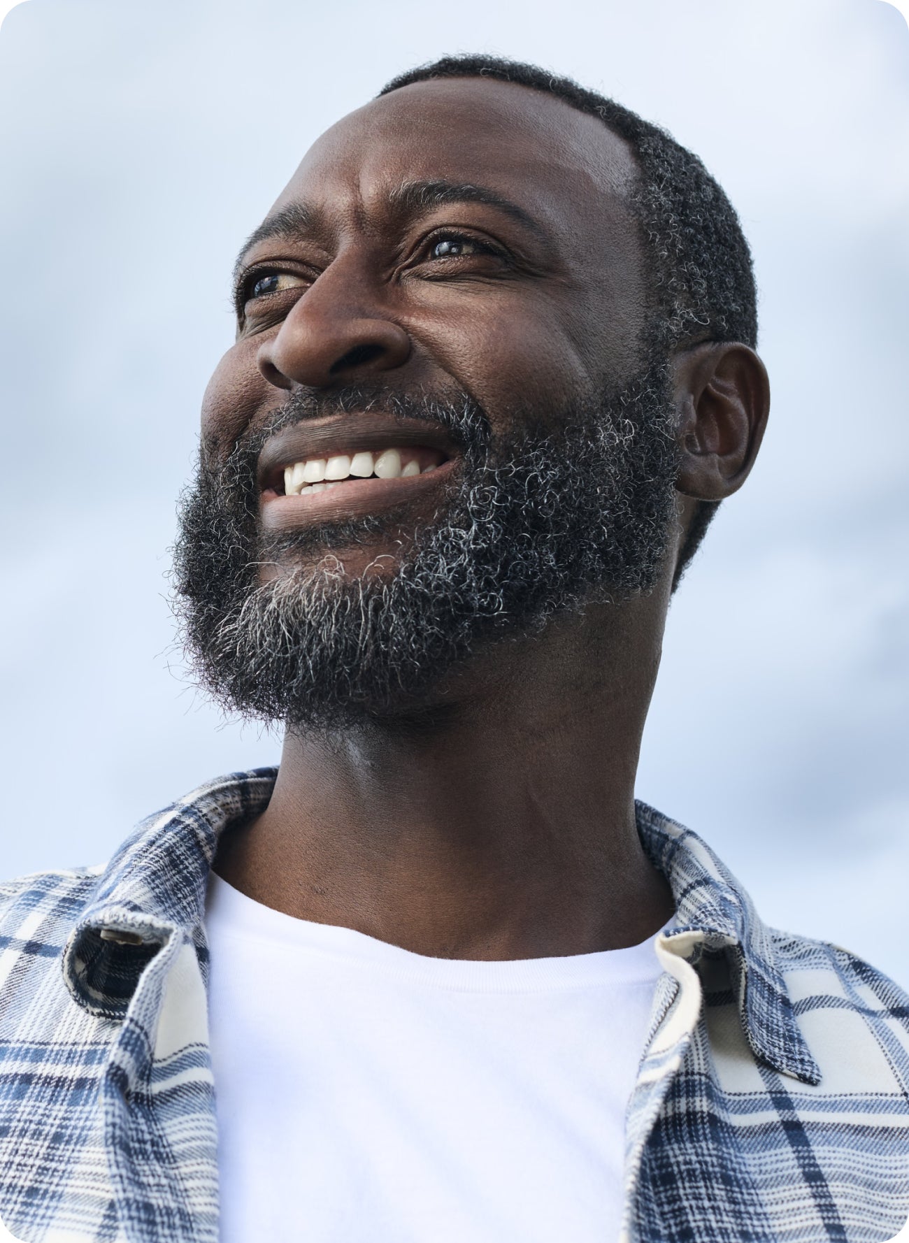 A smiling bearded man looking upwards