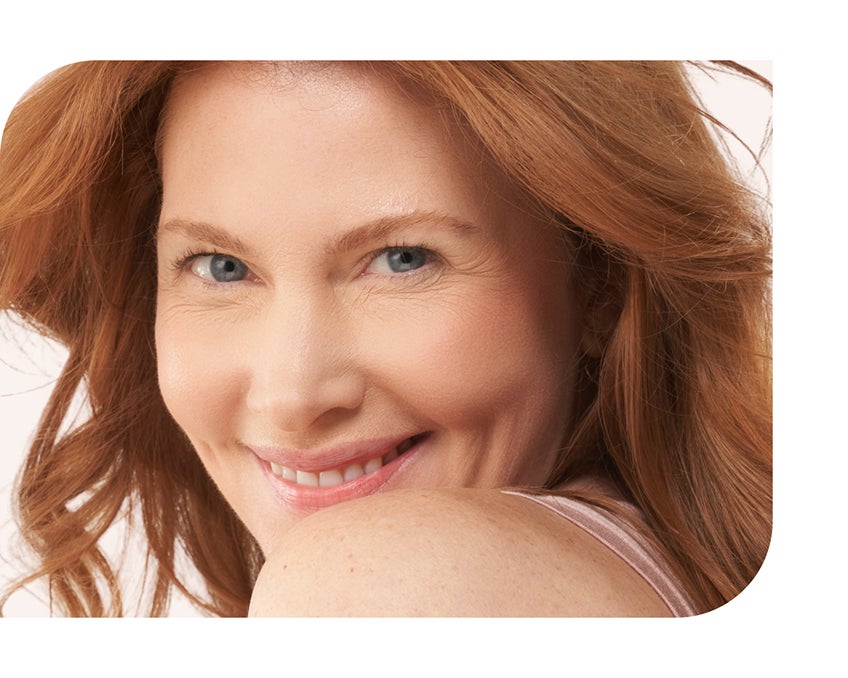 Smiling redhead with blue eyes looking over her shoulder