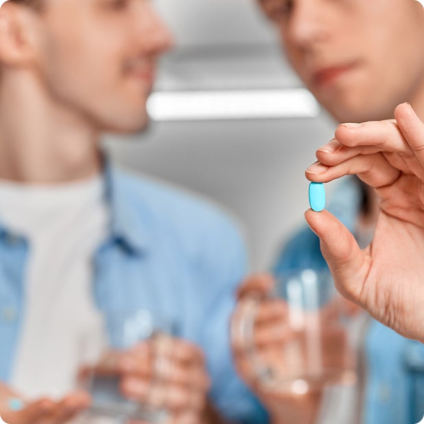 Two men holding a pill bottle, representing PrEP and PEP medication for HIV prevention.