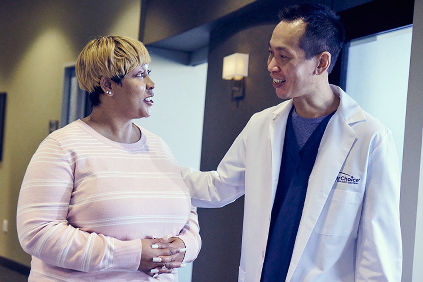 An image of a ClearChoice doctor explaining to his patients the cost for her dental implants, and providing alternatives such as third-party financing options.
